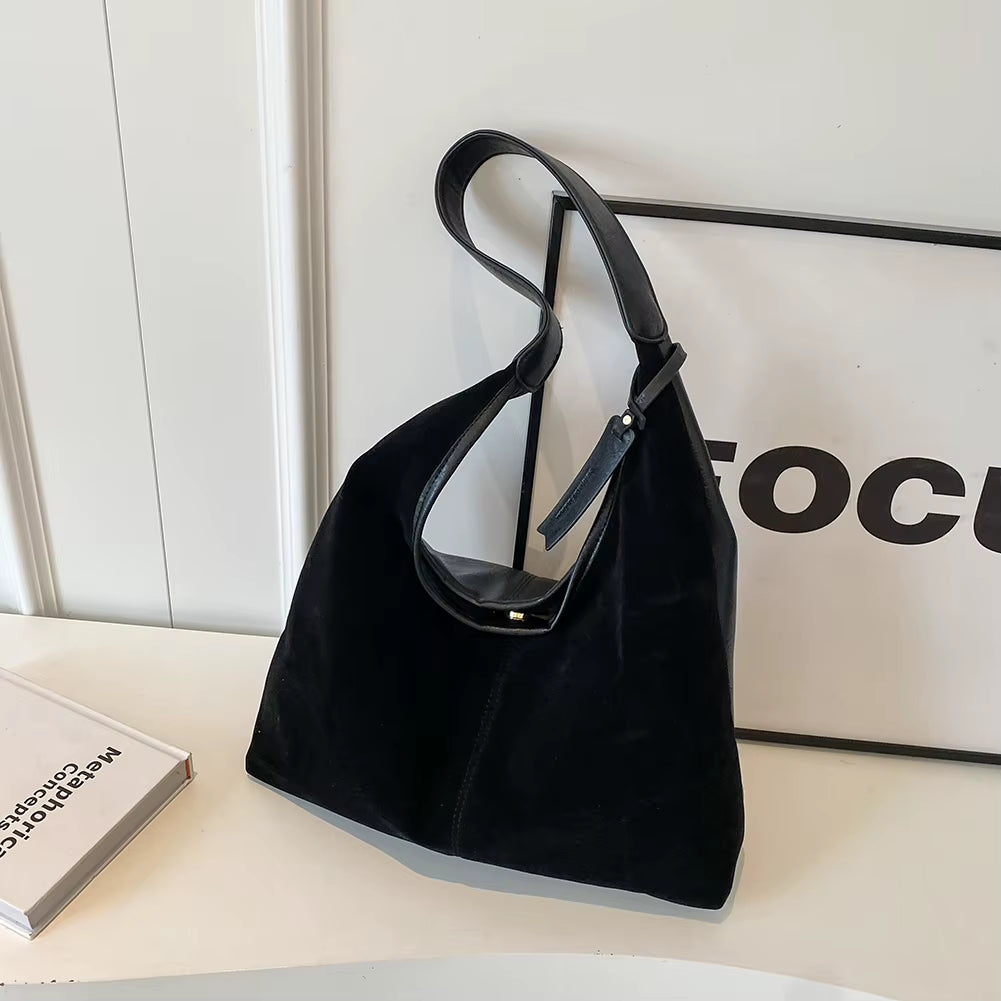 Woman styling a chic brown suede bag, effortlessly complementing her outfit with a timeless and elegant accessory – available at Shop Style Edit.