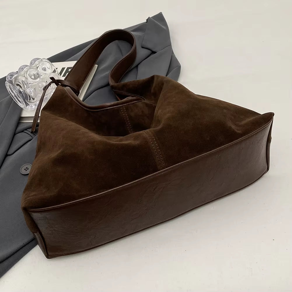 Woman styling a chic brown suede bag, effortlessly complementing her outfit with a timeless and elegant accessory – available at Shop Style Edit.