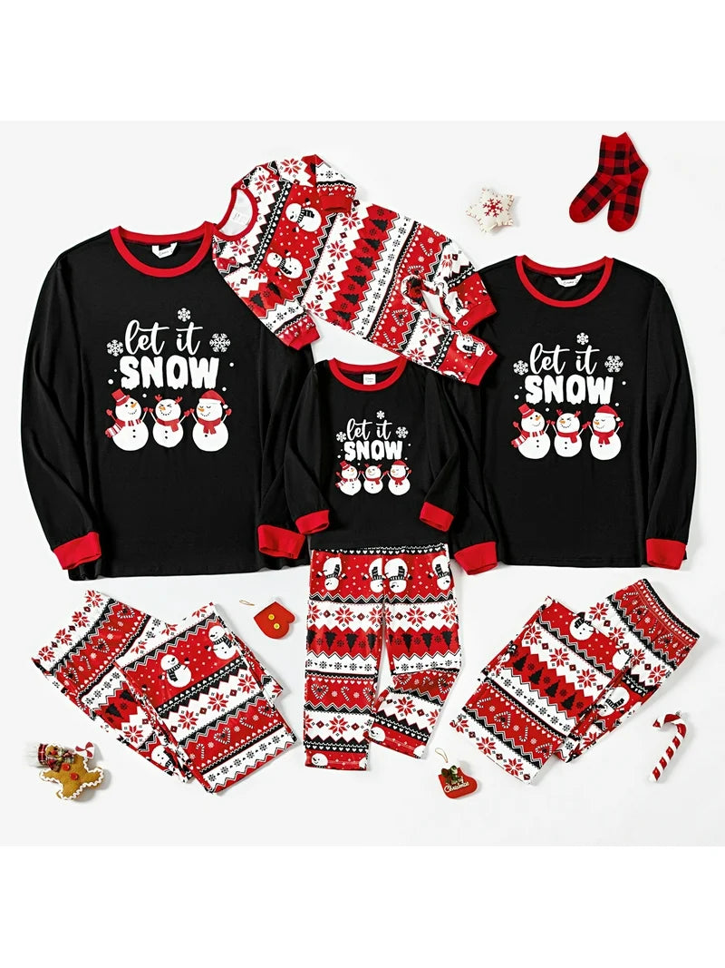Flat lay of Let It Snow matching family Christmas pajamas set with festive décor